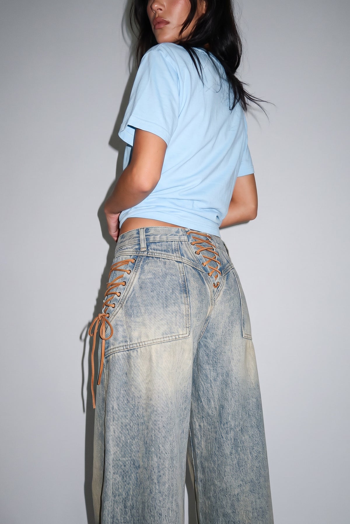 Close side view of the Regan Jeans lace-up ties on the hip and back